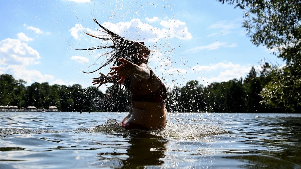 Ein Junge springt in einem Freibad ins Wasser. Planschen macht bei großer Hitze auf jeden Fall mehr Spaß als Unterricht.