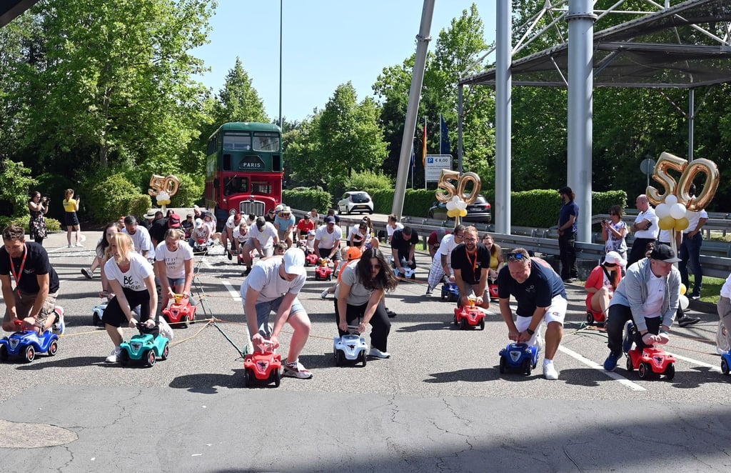 Im Europa-Park ziehen 50 Menschen auf Bobby-Cars den Bus der Kelly Family 50 Meter weit.