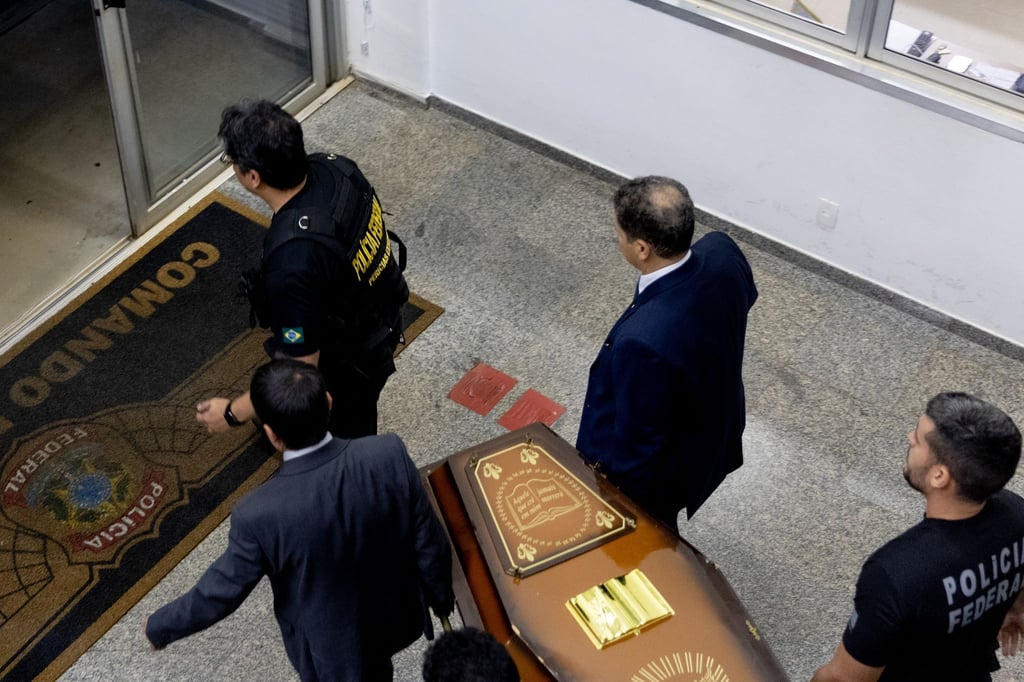 Beamte kommen mit sterblichen Überresten im Hangar der Bundespolizei in Brasilia an.