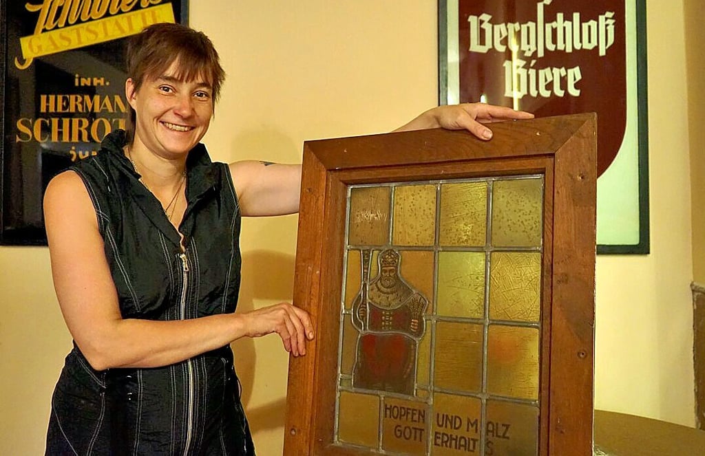 Kneiperin Nicole Schröter mit einem von drei alten Bleiglasfenstern. Ein anderes dürfte bei vielen Salzwedelern Erinnerungen wecken.