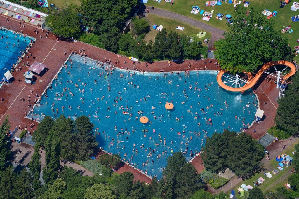 Menschen baden und sonnen sich im Sommerbad am Insulaner im Berliner Bezirk Steglitz. (Luftaufnahme).
