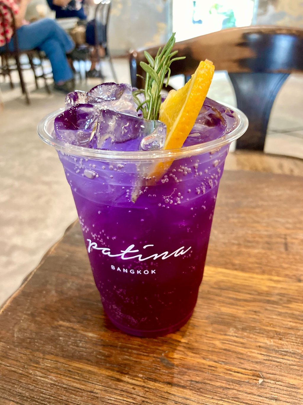 Ein Becher Butterfly Pea Soda. Das Trendgetränk leuchtet in verführerischen Lila-Blautönen und wird aus den Blüten der „Clitoria ternatea“-Pflanze (Schmetterlingserbse) gewonnen.