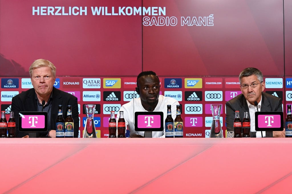 Sadio Mané (M) sitzt während seiner Vorstellung neben dem Vorstandsvorsitzenden Oliver Kahn (l) auf dem Podium.