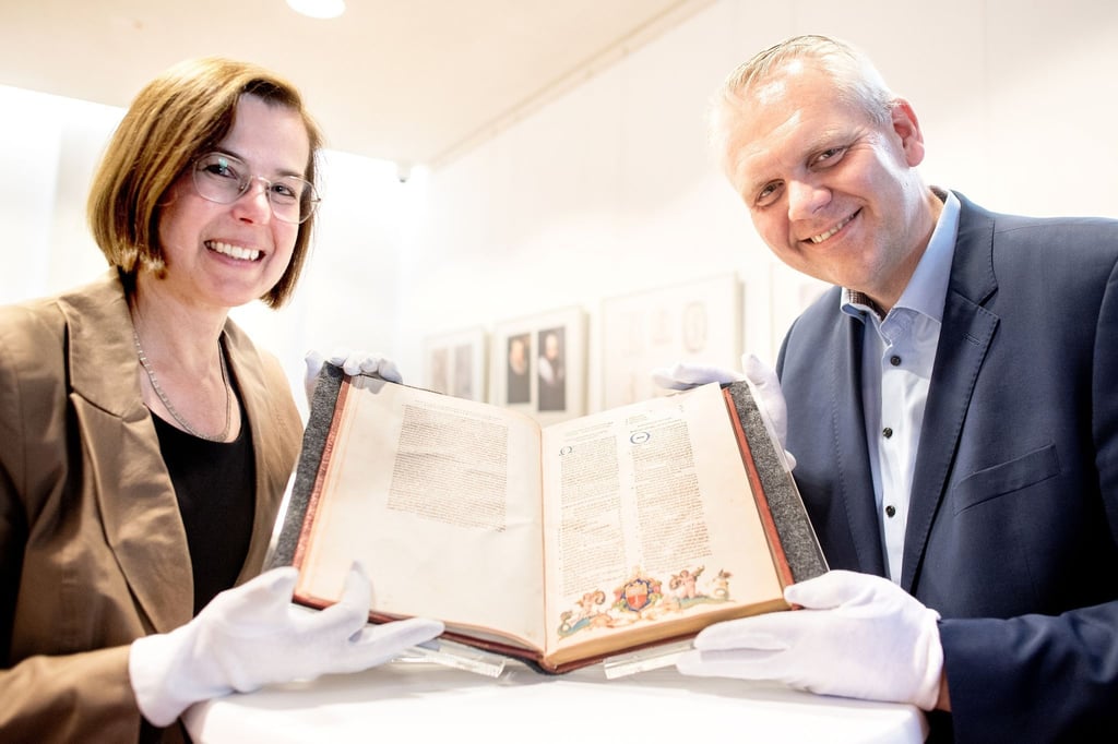 Corinna Roeder, Direktorin der Landesbibliothek Oldenburg, und Björn Thümler (CDU), Wissenschaftsminister in Niedersachsen, zeigen ein Buch mit einer bislang unbekannten Illustration, die möglicherweise von dem Renaissance-Künstler Albrecht Dürer stammt.