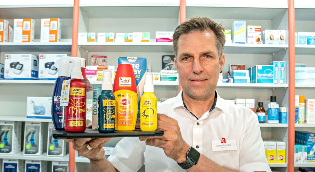 Martin Grünthal zeigt in seinem Geschäft, der Apotheke am Bauhaus, das aktuelle Angebot an Mückenschutz-Produkten.