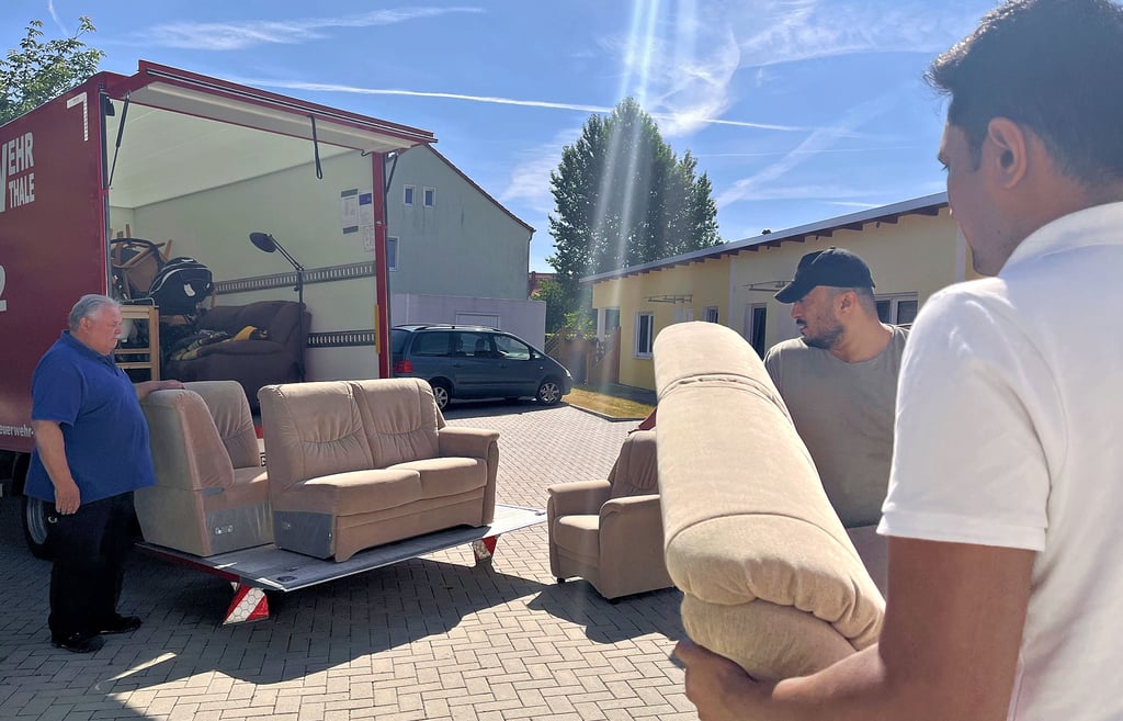 Detlef Ulrich (links) bedient die Hebebühne. Hanan Nannan (Mitte) und Niravkumar Manojkumar Raval laden die Sofas auf.