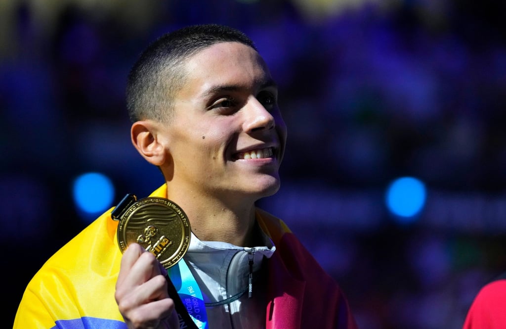 Der Rumäne David Popovici hält seine Goldmedaille bei der Siegerehrung in der Hand.