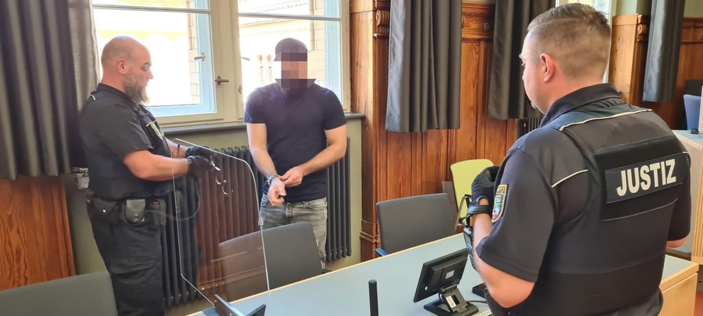 Dem Angeklagten Basil H. werden vor der Urteilsverkündung im Landgericht Magdeburg die Handfesseln abgenommen.