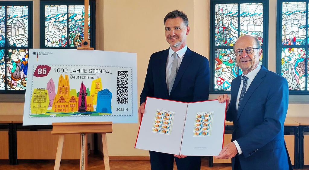 Fabian Leber (links), Unterabteilungsleiter im Bundesfinanzministerium, übergibt die Briefmarke zum Stadtjubiläum an Stendals Oberbürgermeister Klaus Schmotz.