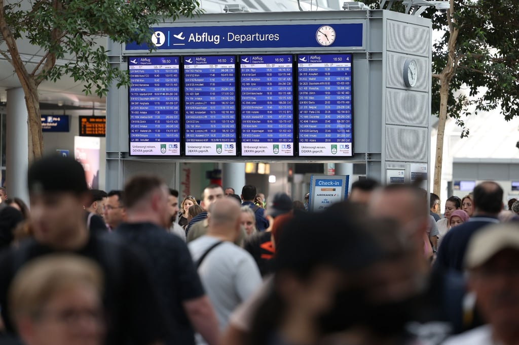 Reisende gehen durch den Flughafen Düsseldorf. Der Ferienstart im bevölkerungsreichsten Bundesland Nordrhein-Westfalen dürfte am Wochenende zu stundenlangen Wartezeiten führen.