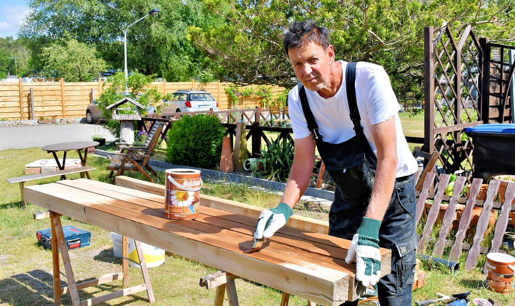 Existenzgründer Bernd Hohaus aus Kleinau beim Streichen von Holzlatten.