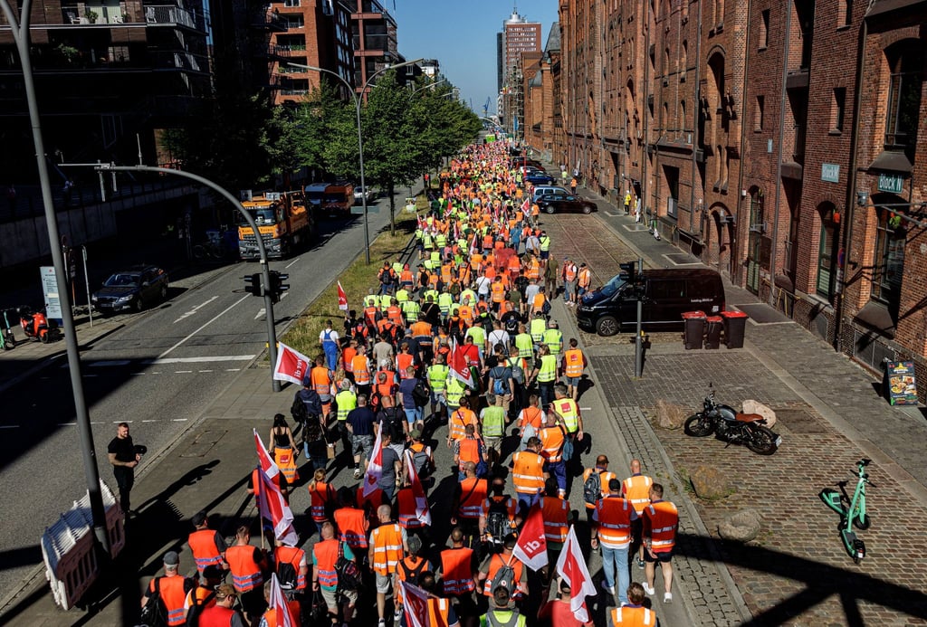 Hafenarbeiter ziehen unter dem Motto „Das Inflationsmonster stoppen“ durch die Hamburger Hafencity.