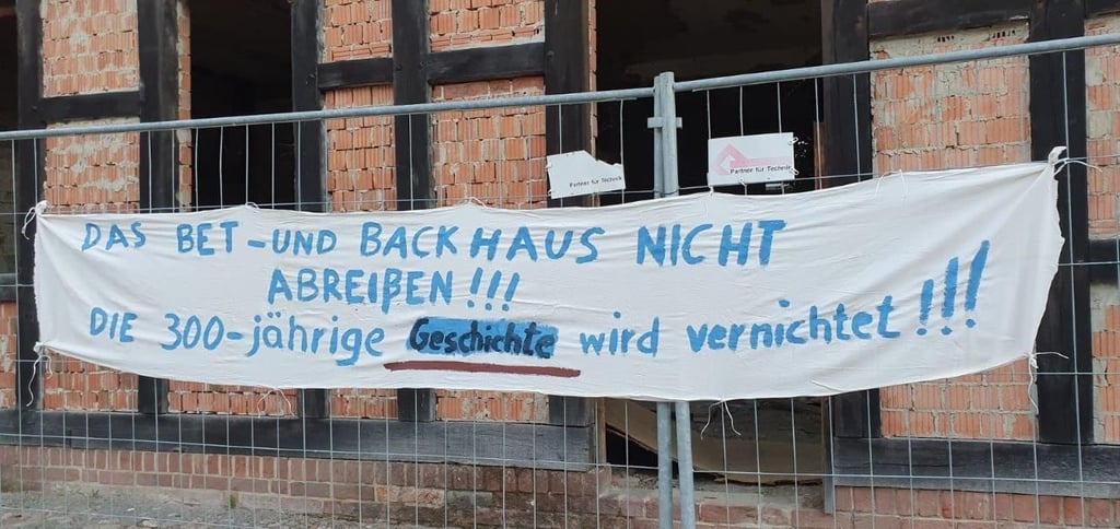 Unbekannte hatten nach Bekanntwerden der Abrissgenehmigung für das Back- und Bethaus ein Plakat am Zaun angebracht.