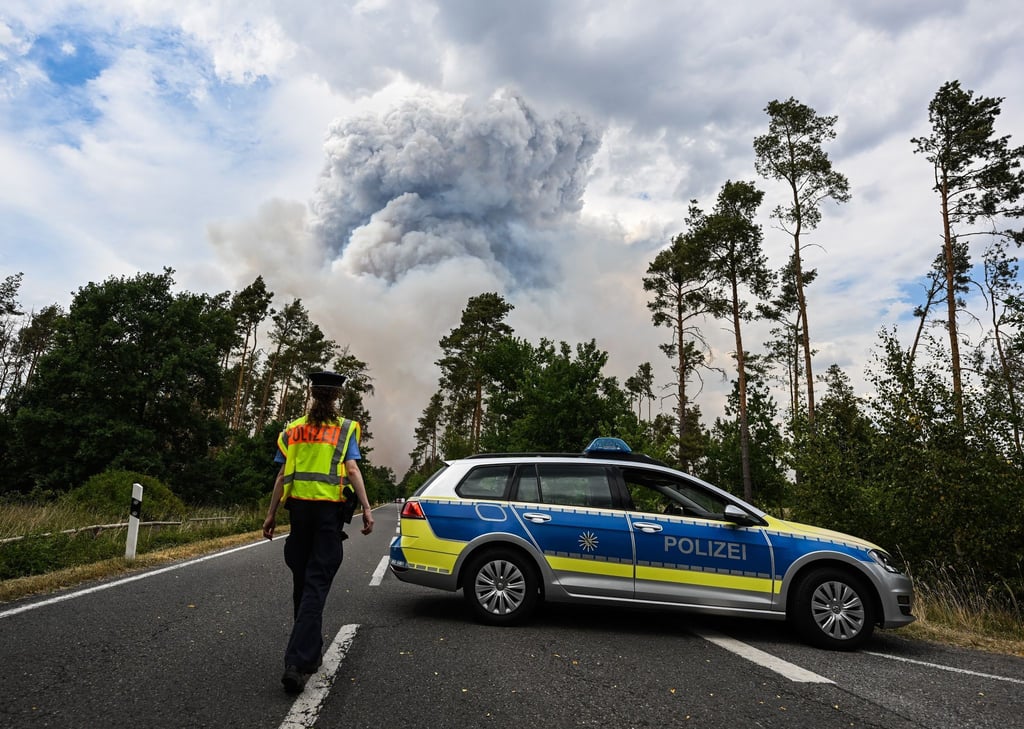 Ein Polizeiauto sperrt die Straße im Waldbrandgebiet in der sächsischen Gohrischheide ab.