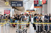 Passagiere stehen in einer Schlange von mehreren hundert Metern für die Sicherheitskontrolle am Flughafen Köln Bonn an.