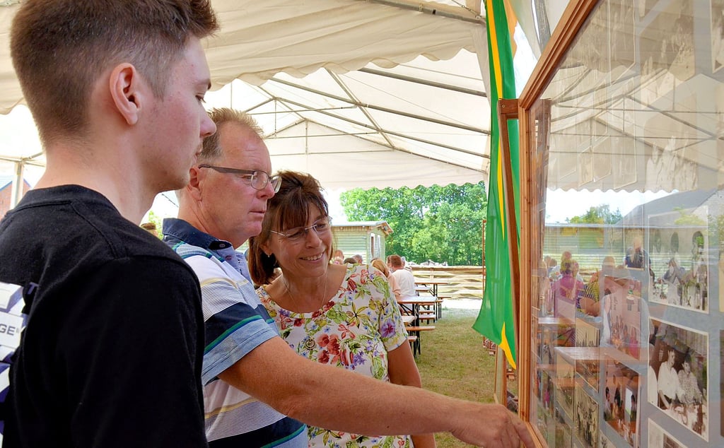 Julian (von links) und Robert Kummert sowie Meike Thiele sahen sich historische Fotos aus Lagendorf an. Manch ein Erlebnis wurde dabei wieder lebendig.
