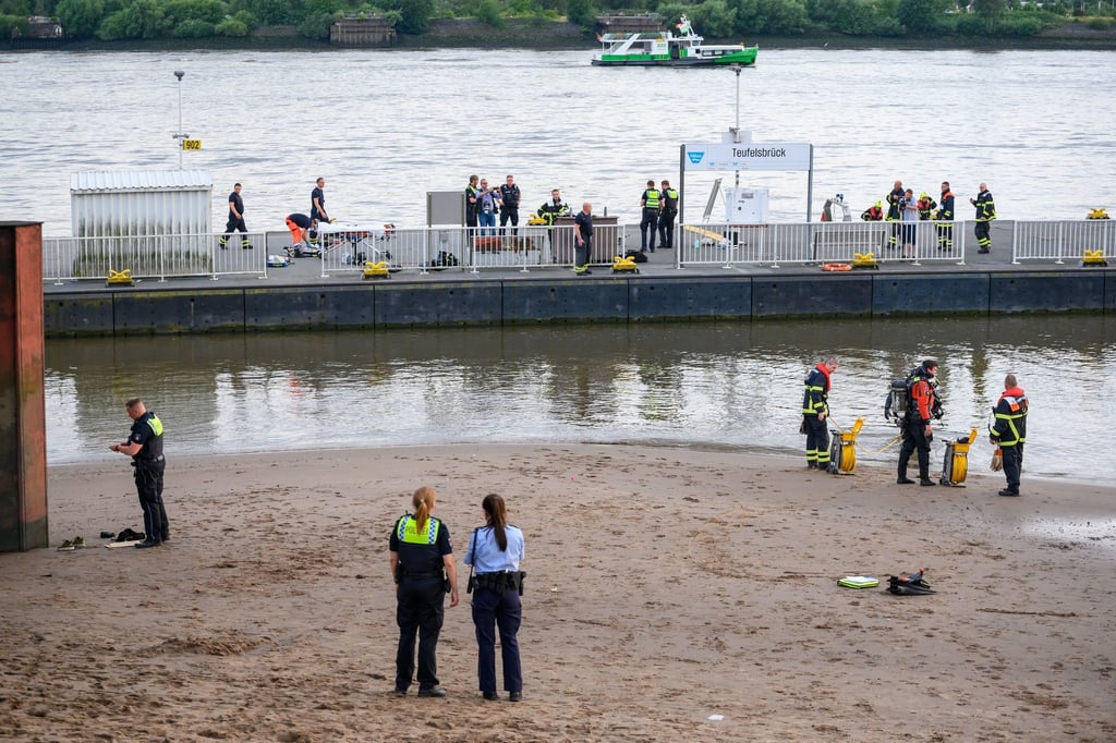 Einsatzkräfte von Feuerwehr, DLRG und Polizei während der Suche auf dem Anleger "Teufelsbrück" und am Ufer der Elbe.