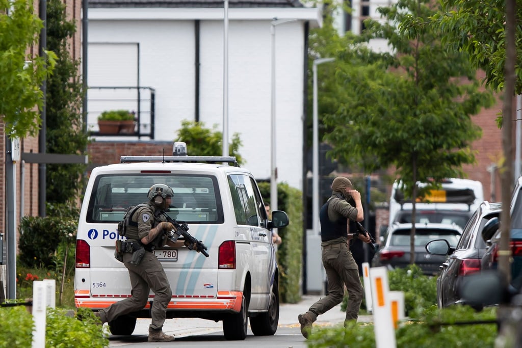 Polizeibeamte mit Spezialausrüstung am Ort einer Geiselnahme in Merksplas.