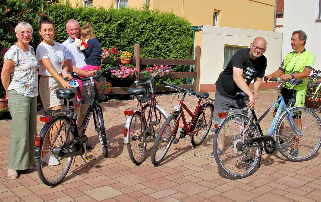 Mario Friebus und Norman Rentner (von rechts) stellen noch den Sattel eines der gespendeten Räder ein. Anatolij und Natalija Lastowets mit Tochter Yeva und Familienpatin Birka Friebus freuen sich sehr über die Spende. Die übrigen Räder sind für eine weitere von Familie Friebus betreute Familie gedacht.