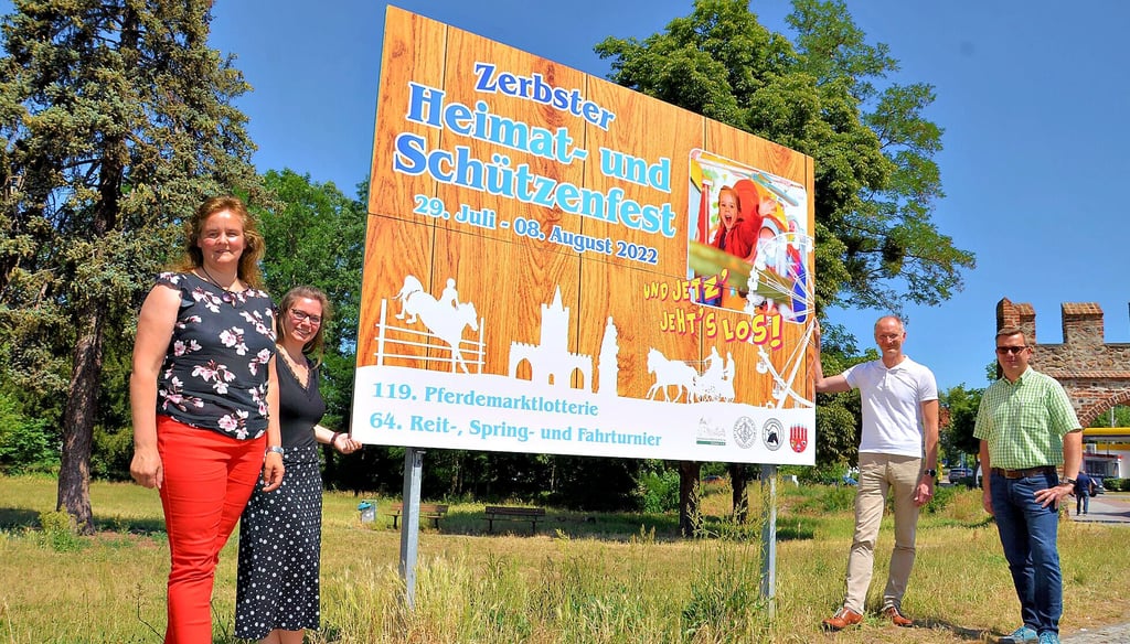 Mandy Baum und Sabrina Dietz (v.l.; beide Askom Werbung) sowie Bürgermeister Andreas Dittmann (2.v.r.) und Marco Paul (Zerbster Verkehrsverein) präsentieren das Werbeplakat für das diesjährige Heimat- und Schützenfest.