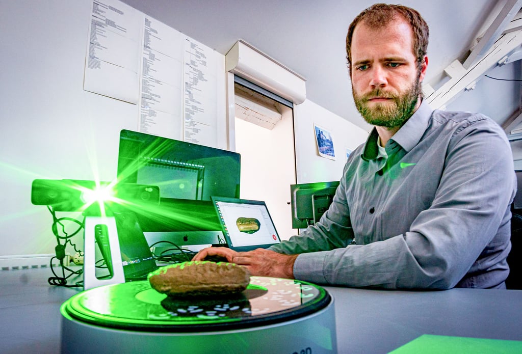 Doktorand Florian Linsel zeigt im Informatik-Institut der Uni Halle, wie man Tontafeln mit Keilschrift scannt und digitalisiert.