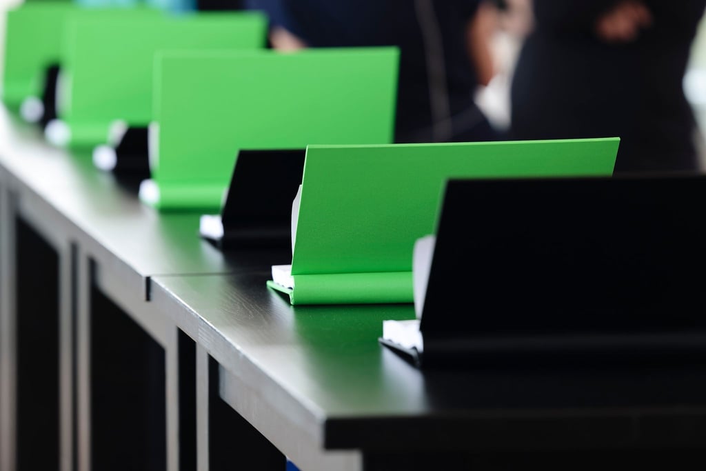 Exemplare des Koalitionsvertrages liegen in den Farben Grün und Schwarz auf einem Tisch.