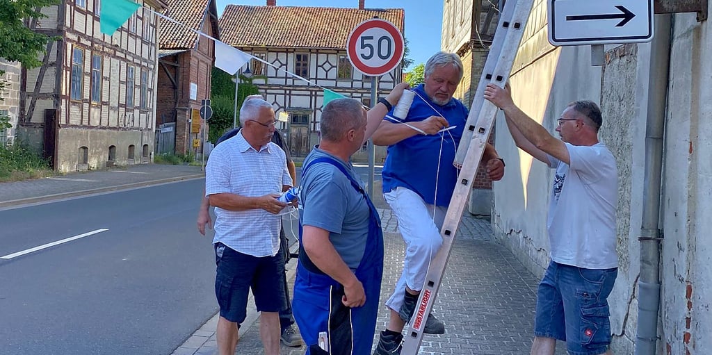 Überall in Dedeleben werden in Vorbereitung auf das anstehende Volks- und Schützenfest Wimpel aufgehängt, um das Dorf zu schmücken.