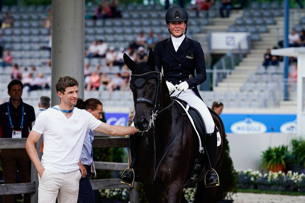 Thomas Müller und seine Frau, Dressurreiterin Lisa Müller auf dem Pferd Chuck Bass, kommen nach dem Ritt aus dem Dressurstadion.