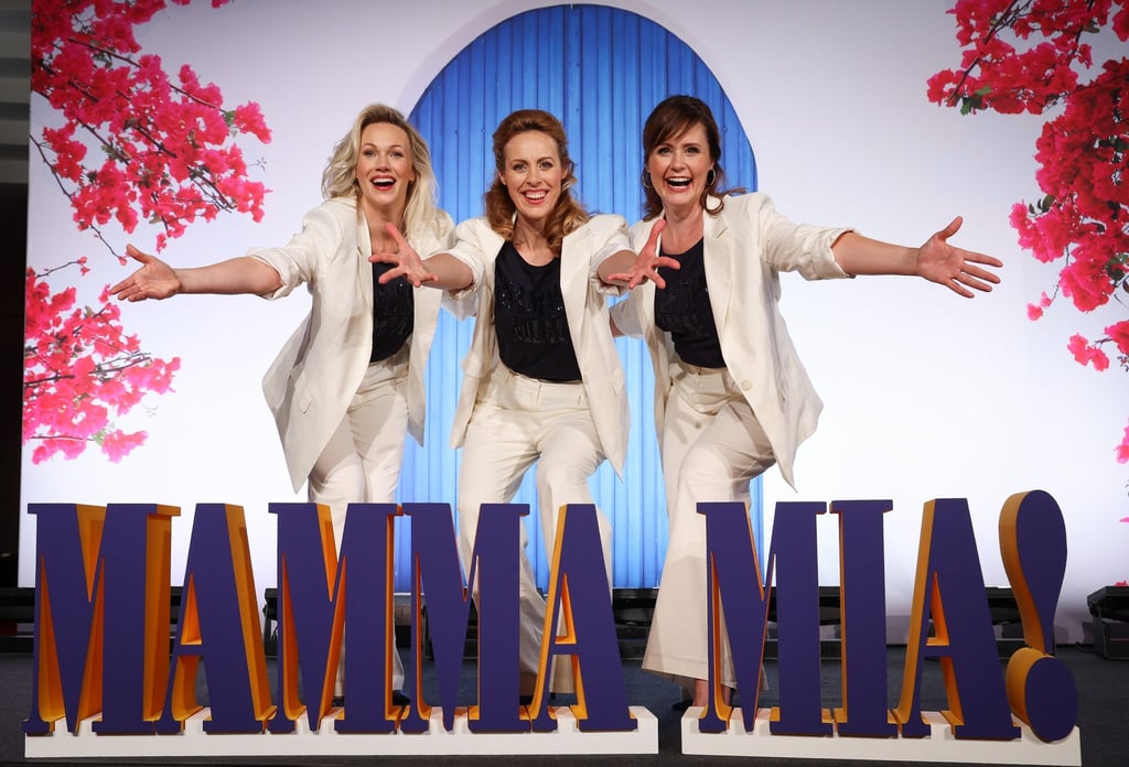 Die Musical-Darstellerinnen Jennifer van Brenk (Tanja), Anna Thoren (Donna, alternierend) und Franziska Lessing (Rosie) stehen bei der Präsentation der Musical-Produktion „Mama Mia!“ auf einer Show-Bühne.