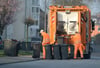 Zwei Männer von der Müllabfuhr entleeren graue Tonnen in Gelsenkirchen. Die Müllgebühren in den deutschen Großstädten klaffen einer Studie zufolge teils deutlich auseinander.