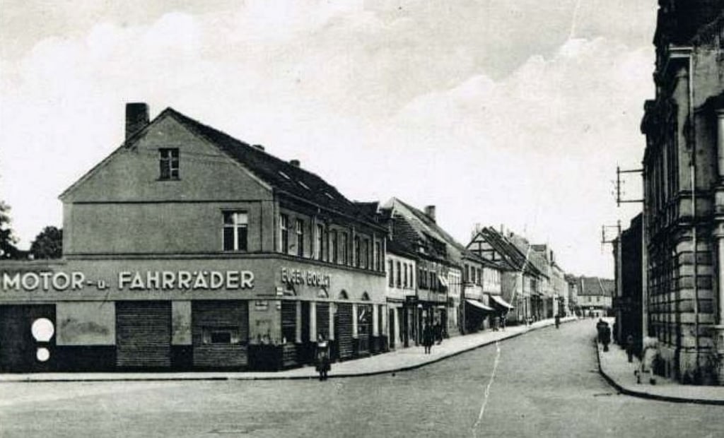 Die Straße noch unter dem Namen "Wilhelm-Külz-Straße mit dem Motor- und Fahrradgeschäft" im Vordergrund.