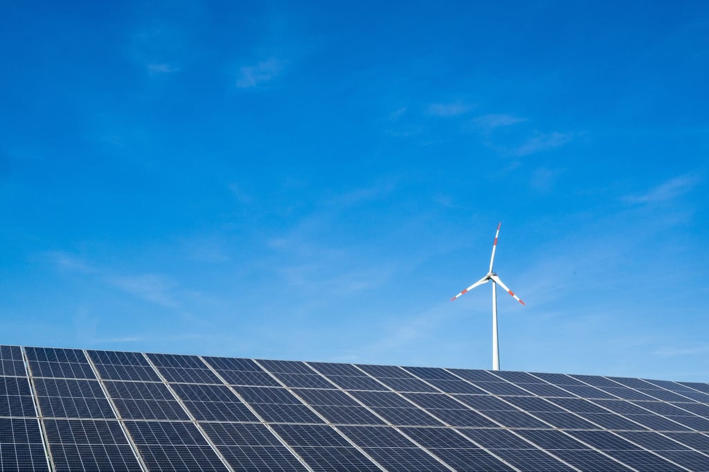 Ein Windrad hinter einem Solarfeld. Ab dem 1. Juli müssen Stromkunden die Förderung des Ökostroms nicht mehr über die Stromrechnung zahlen.