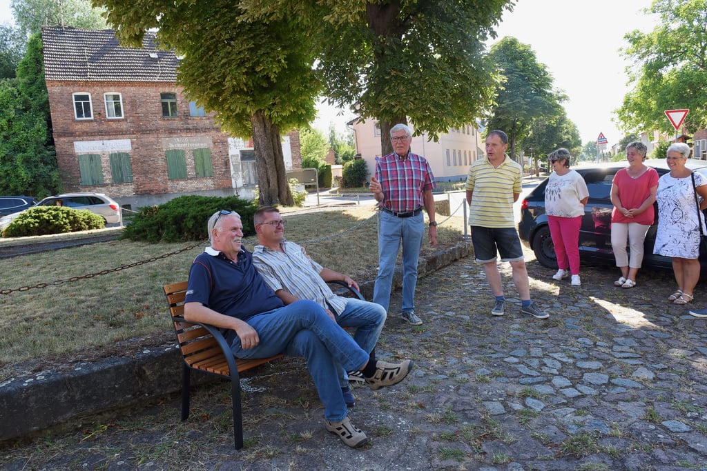 Anlässlich des 1.090. Geburtstags der Gemeinde Röblingen hat der Ortschaftsrat zwei Sitzbänke zum Verweilen spendiert. Wie hier am Denkmal in Unterröblingen hat neue Sitzgelegenheit einen Schattenplatz bekommen. Bürgermeister Jürgen Ludwig und Ortsbürgermeister Ronald Lange waren die ersten „Probesitzer“.
