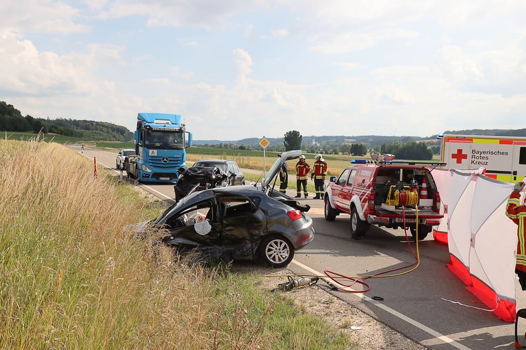 Einsätzkräfte der Feuerwehr und des Rettungsdienstes arbeiten an der Unfallstelle. Eine 87 Jahre alte Autofahrerin ist am Mittwoch bei einem Unfall in Burgau (Landkreis Günzburg) ums Leben gekommen.