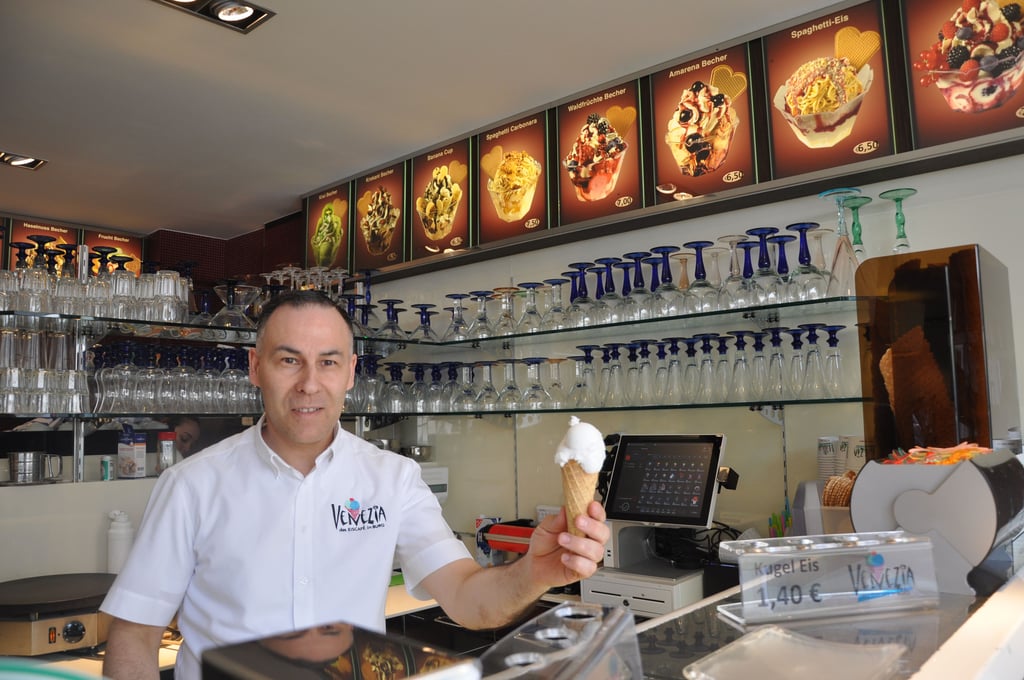 Paulo Costa, der zusammen mit seiner Frau Maria das Eiscafé Venezia in Burg betreibt, gibt eine Kugel Zitroneneis raus.