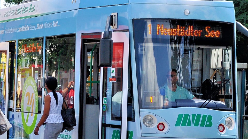 Eine Straßenbahn der MVB hält an einer Haltestelle.