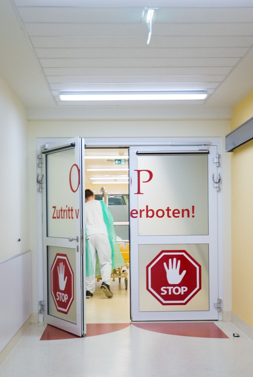 Ein Pfleger schiebt in der Asklepios Klinik Altona in Hamburg einen Patienten durch die Personenschleuse in den OP-Bereich.