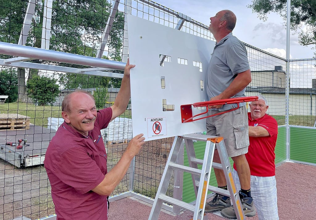 Der Ortsbürgermeister von Welsleben, Hans-Jürgen Korn (l.), und MTV-Vereinsvorsitzender Frank Thäle (r.) präsentieren eines der neuen zusätzlichen Sportangebote auf dem Sportplatz: Basketball.