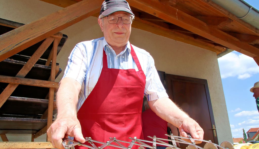 Wolfgang Boggasch schneidet den Kuchen am Dorfbackofen in Dobritz, wenn er noch ganz warm ist. Die Männer, die den Dorfbackofen im Dorf betreiben, arbeiten seit vielen Jahren zusammen und kennen die Eigenheiten des großen Backofens.