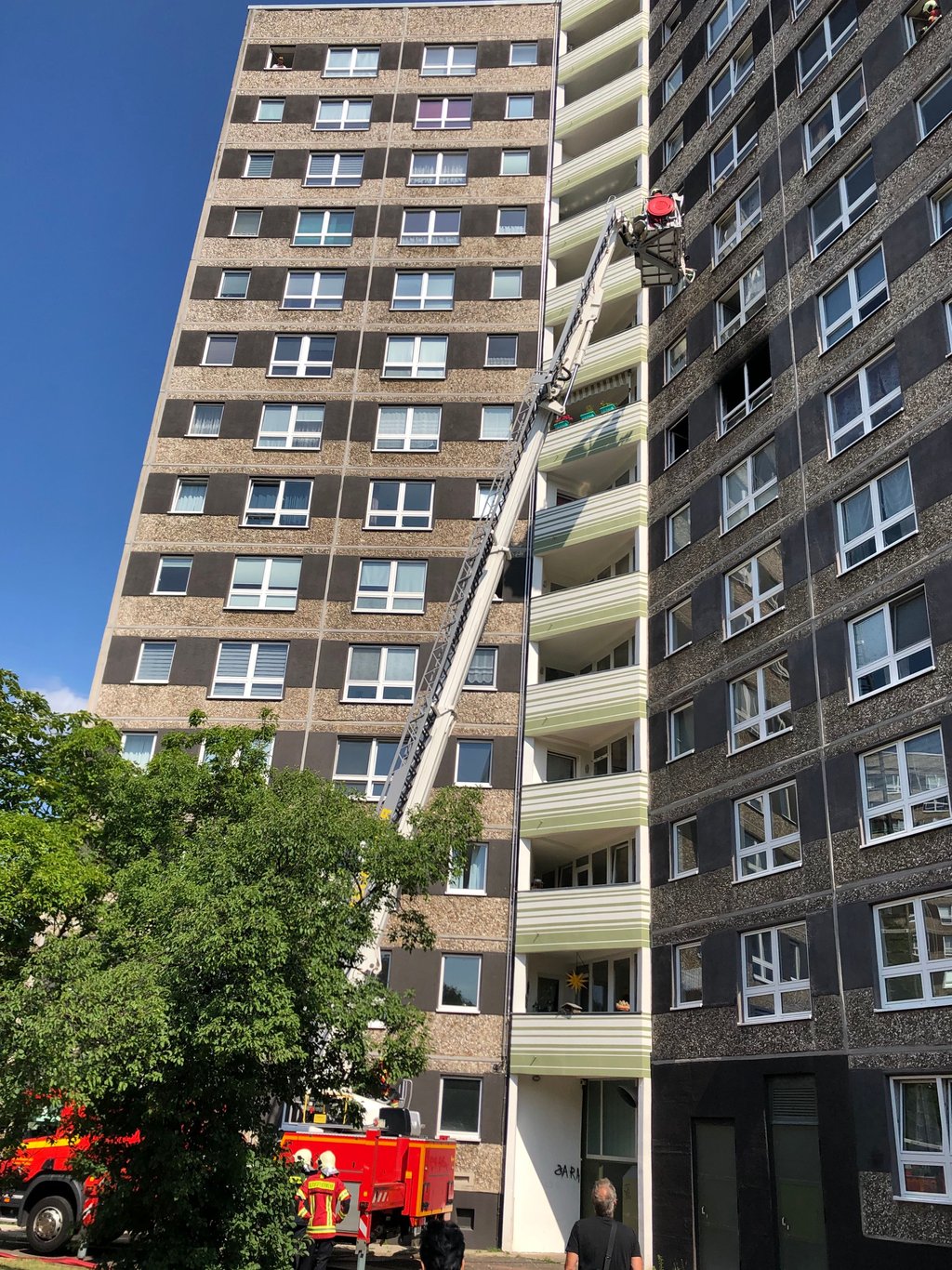 Die Feuerwehr im Einsatz mit Drehleiter bei Brand in einem Y-Haus.