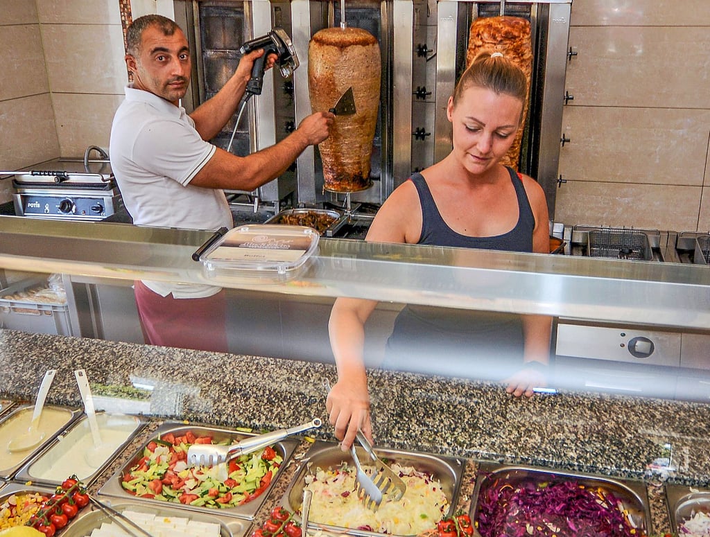 Osman Kacaoglu und Sabrina Ohrstedt bereiten beim Musti-Bistro in Wanzleben die Speisen für die Kunden vor.