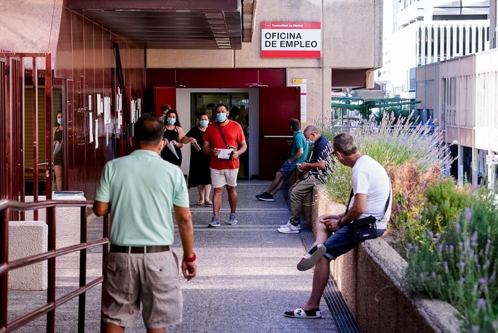 Menschen stehen vor einem Arbeitsamt in Madrid.