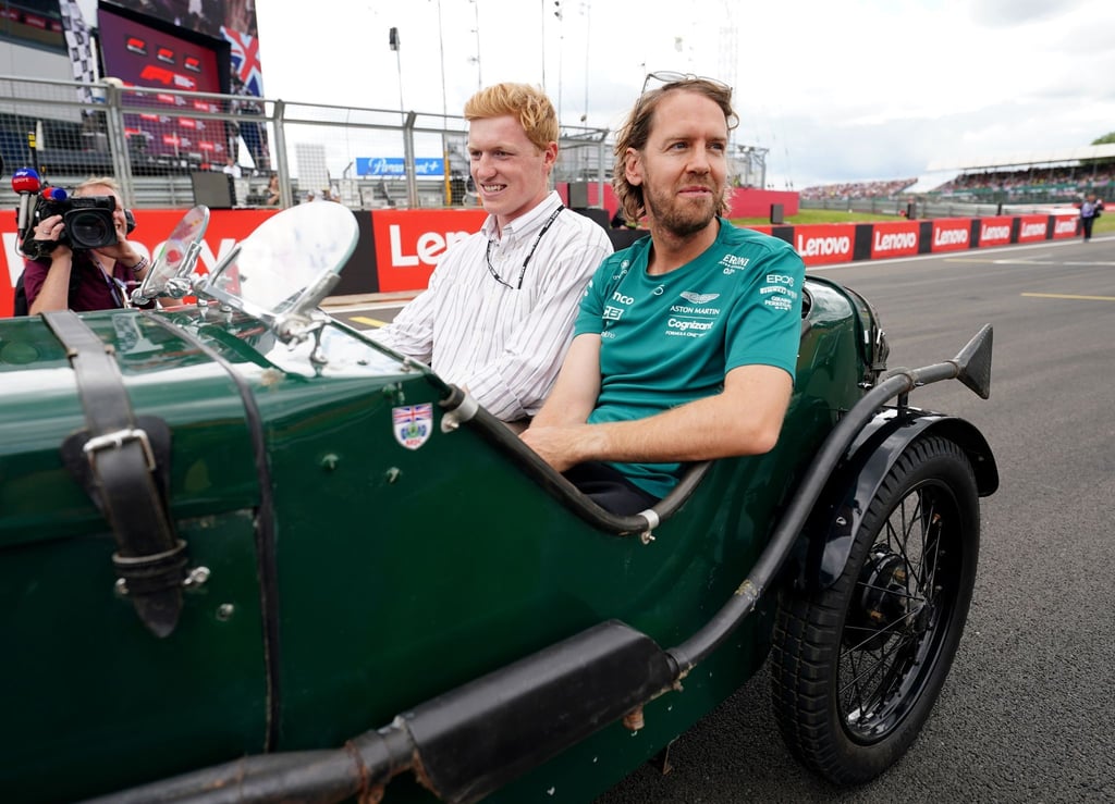 Sebastian Vettel (r) wird in einem Oldtimer auf die Rennstrecke chauffiert.