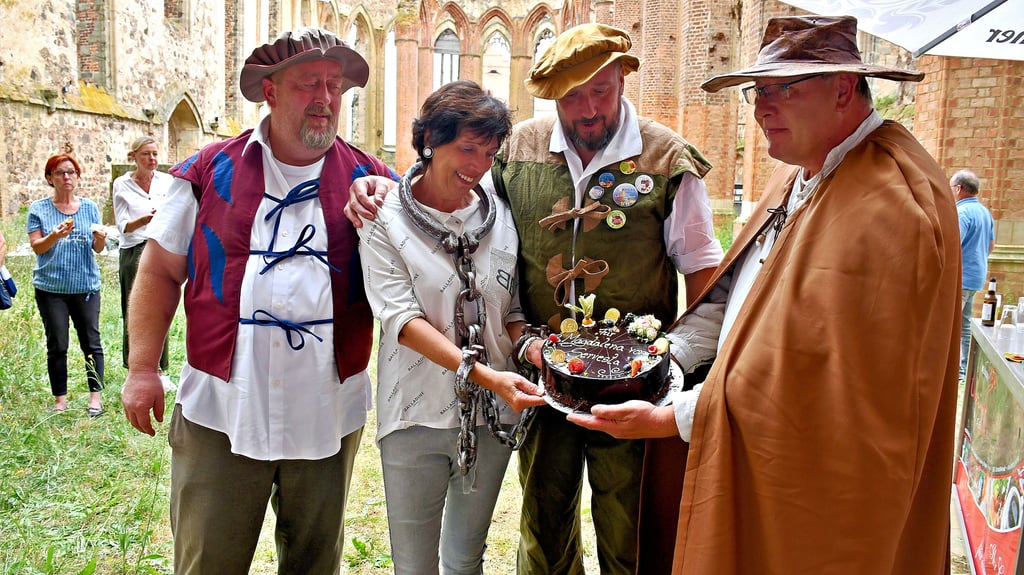 Die Männer, die Viola Tiepelmann bei ihren legendären Nachtstadtführungen begleitet haben: Uwe Stück als Scharfrichter, Tom Hebäcker als Gastronom sowie Roland und Daniel Hinze als Fackelmeister (v.r.) verabschieden die Chefin der Zerbster Tourist-Information mit einer Torte. Sie selbst schlüpfte in die Rolle der Butterjungfer, der Magdalena von Servesta.