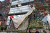 Documenta-Mitarbeiter bauen das umstrittene Großbanner "People's Justice" auf dem Friedrichsplatz ab.