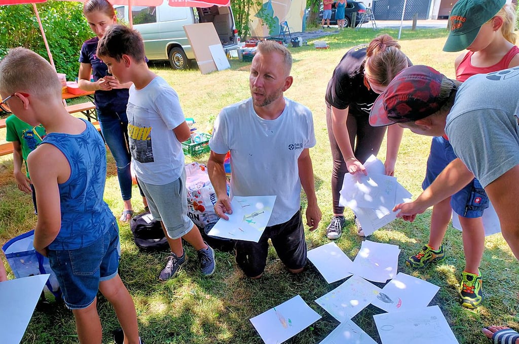 Immer mittendrin. Der Potsdamer Graffiti-Künstler Marvin Bieß wertet mit den Kindern in Mühlanger die ersten Skizzen aus.