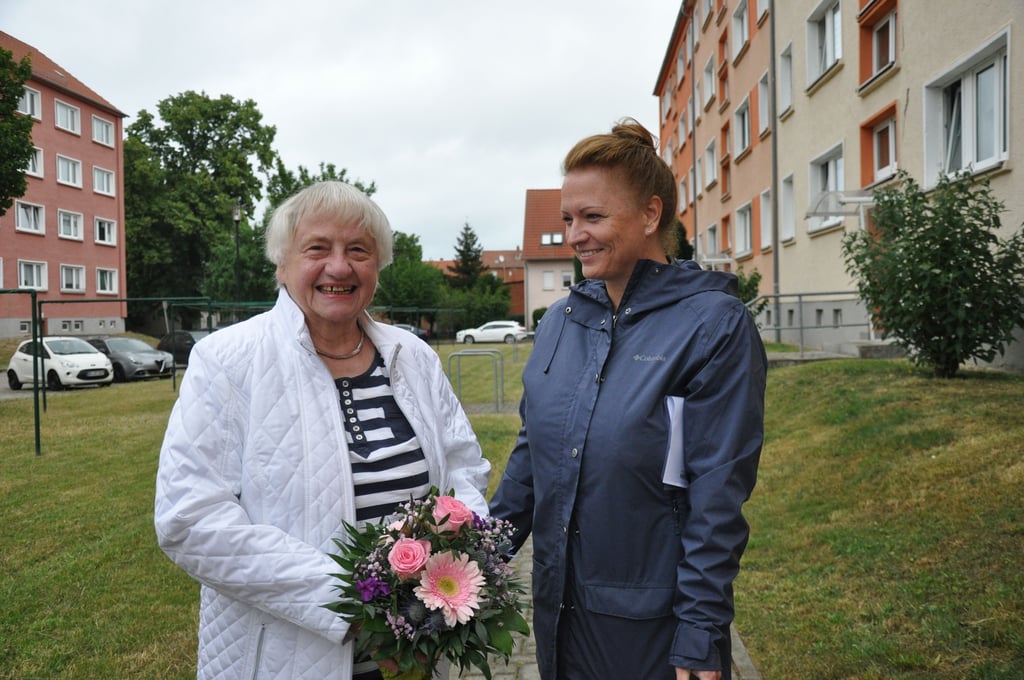Anita Bollmann, erste Mieterin in Haldensleben mit Mieterstrom der Wobau, freut sich über den technsichen Fortschritt. Melanie Offelmann überreicht ihr einen Blumenstrauß.