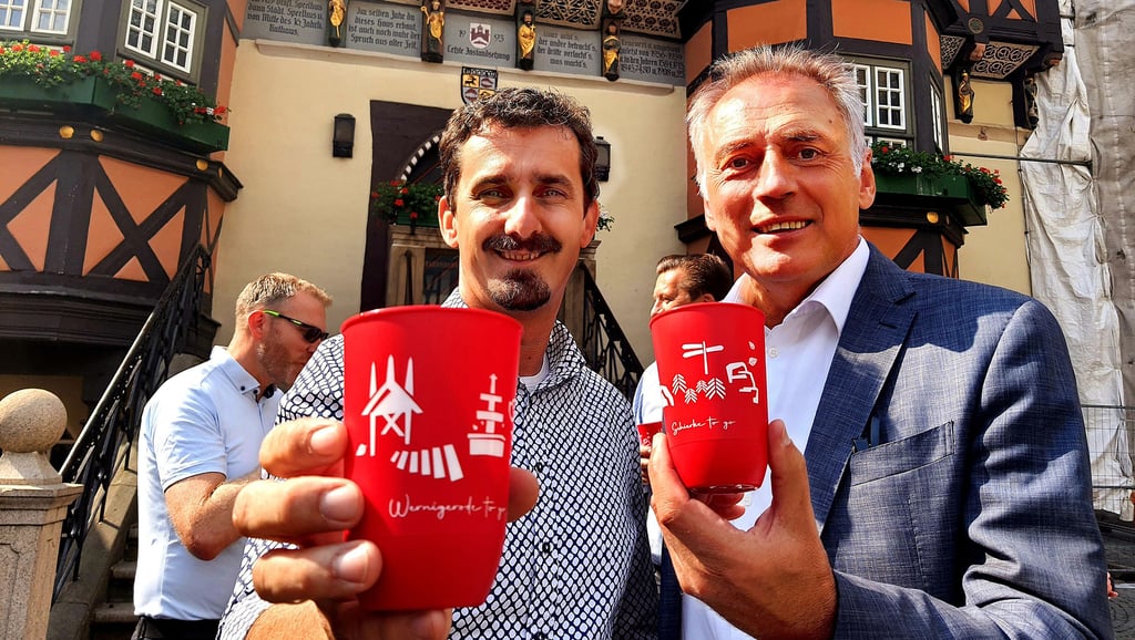 Wernigerodes Oberbürgermeister Peter Gaffert (rechts) und Chef-Touristiker Andreas Meling mit den neuen Wernigerode-Mehrweg-Bechern.