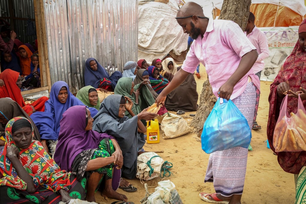An Somalier, die vor der Dürre geflohen sind, werden am Rande der Hauptstadt Mogadischu Lebensmittelspenden verteilt.