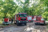 Ein Fahrzeug der Feuerwehr fährt in der Nähe des Einsatzortes durch den Wald.